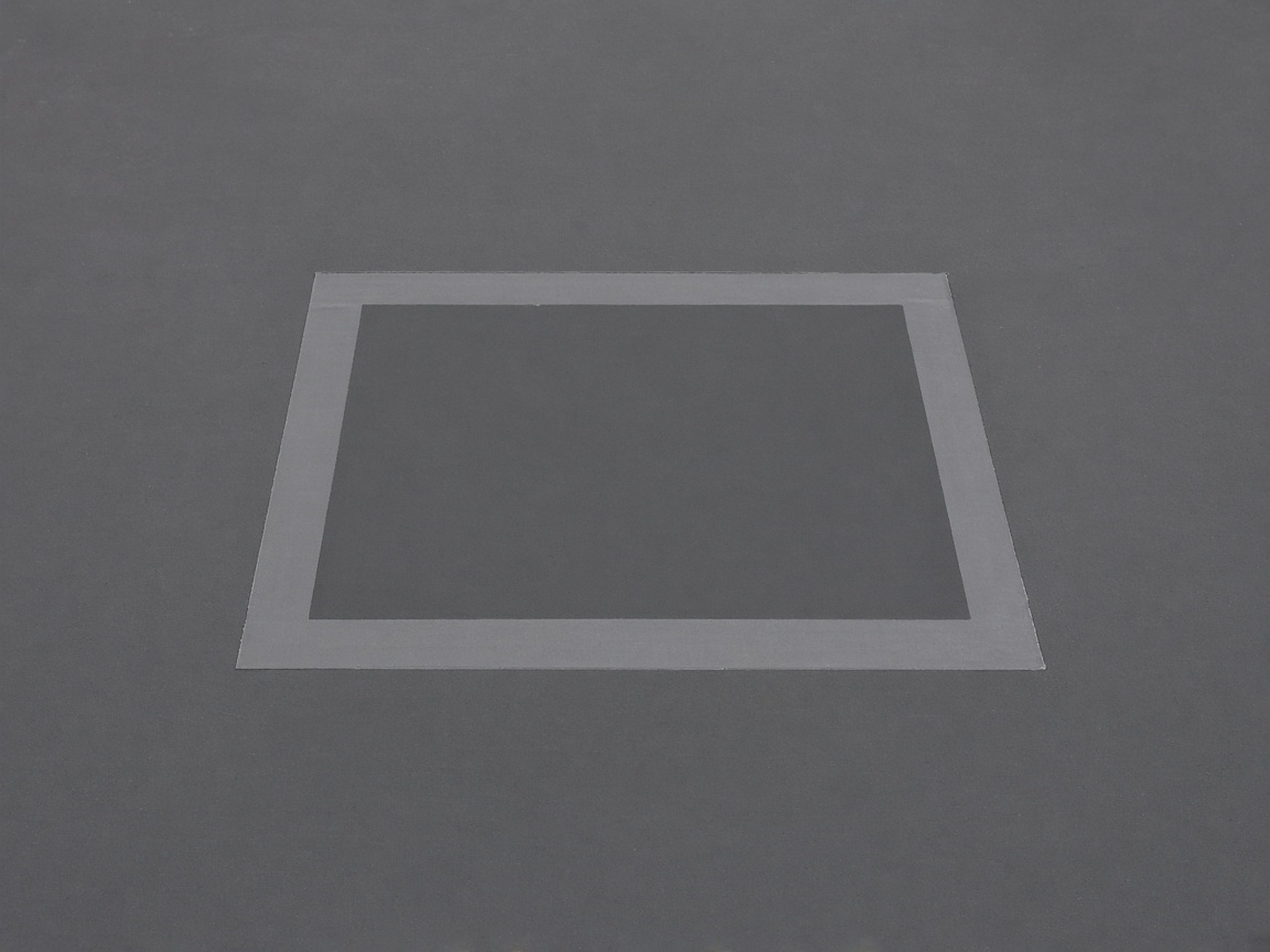 A rectangular membrane repair patch on a commercial roof